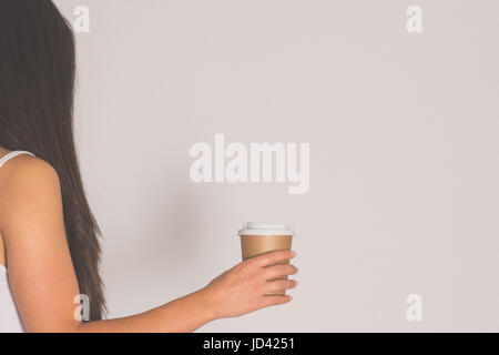 Donna che mantiene la carta marrone tazza di caffè caldo. Foto Stock