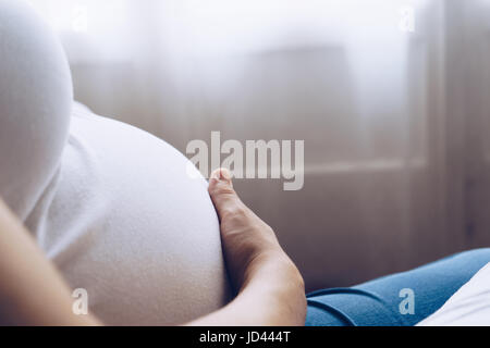 Close up della giovane donna incinta toccando il suo ventre Foto Stock