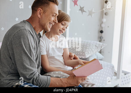 Incantevole famiglia vivace la lettura di una bella storia insieme Foto Stock