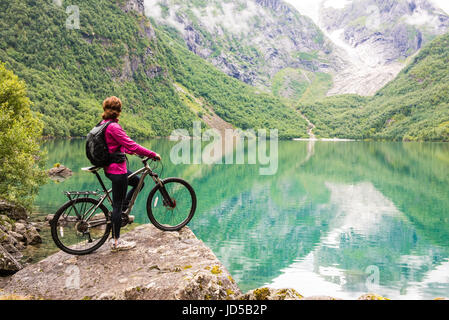 Percorsi in bicicletta donna in Norvegia contro il pittoresco paesaggio Foto Stock