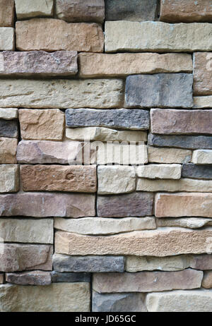 Foto verticale dei blocchi di pietra muro fatto di dimensioni irregolari di blocchi di pietra, per sfondo astratto e texture Foto Stock