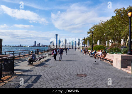 NEW YORK CITY - 26 settembre 2016: persone che passeggiano e seduti sui banchi a Battery Park sulla punta meridionale di Manhattan Foto Stock