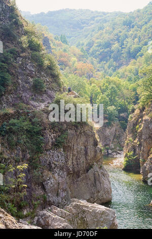 Uomo si arrampica a monte lungo il fiume Ardeche in Francia Foto Stock