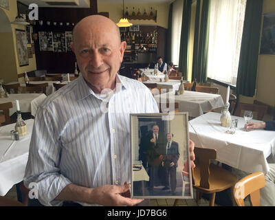 Mainz, Germania. 17 Giugno, 2017. Inkeep Bruno Bellini detiene una foto in cui egli può essere visto con l'ex cancelliere Helmut Schmidt al ristorante Da Bruno a Mainz, Germania, 17 giugno 2017. Bruno è in lutto per il suo più famoso ospite - Helmut Kohl apparentemente abbiamo cenato al suo ristorante 'centinaia di volte". Egli ha affermato di aver conosciuto la ex cancelliere tedesco e. Kohl scomparso all'età di 87 in Eggershaim il 16 giugno 2017. Egli era il Cancelliere per 16 anni e capo del partito CDU per un quarto di secolo. Foto: Andrea Löbbecke/dpa/Alamy Live News Foto Stock