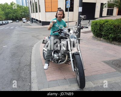 Uomo in posa su una motocicletta Foto Stock