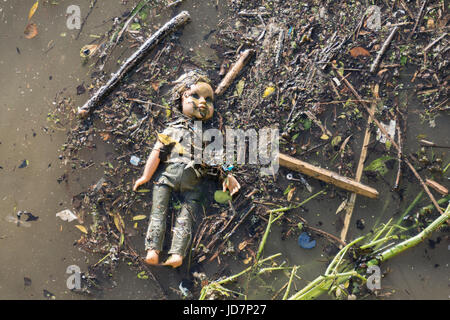 Un bambino la bambola forlornly flottante nel fiume Thames, London, Regno Unito Foto Stock