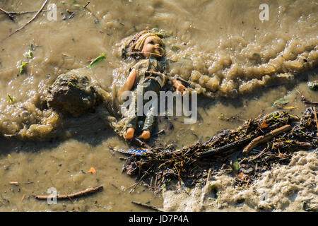 Un bambino la bambola forlornly flottante nel fiume Thames, London, Regno Unito Foto Stock