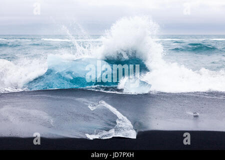 Grandi pezzi di ghiaccio del ghiacciaio essendo lavato fino a una spiaggia da la Laguna di Jokulsarlon in Islanda Foto Stock