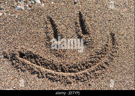 Smiley face disegno su una spiaggia piccola pietra Foto Stock