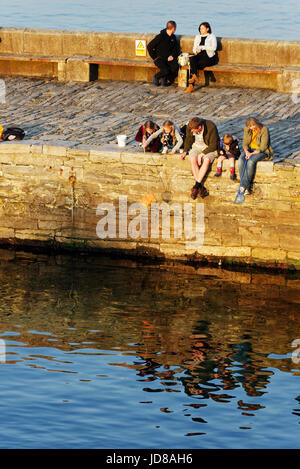 La gente la cattura di granchi off il molo a Swanage nel Dorset Foto Stock