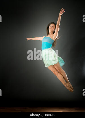 Femmina danzatore di balletto saltando metà aria, le gambe insieme, studio shot. caucasian montare piuttosto skinny athletic Foto Stock