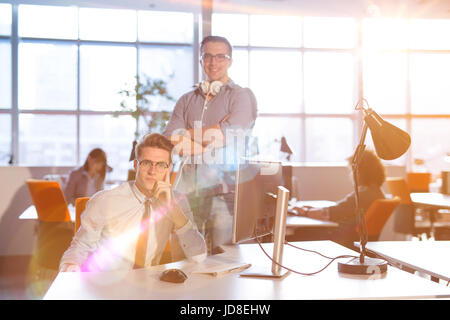 Giovane imprenditore aiutando il suo collega per risolvere il problema del lavoro Foto Stock