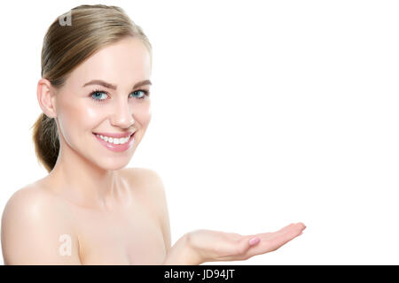 Ragazza che mostra vuoto lo spazio di copia su aprire il palmo della mano per il testo o per prodotto, sfondo bianco. Ragazza sorridente presentando punto. Proponendo il prodotto. Annuncio pubblicitario Foto Stock