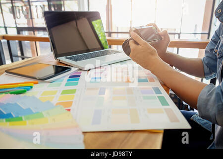 Graphic Designer Sono guardando la telecamera durante il lavoro. Foto Stock