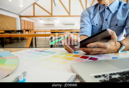 La progettazione grafica e i campioni di colore e le penne su una scrivania. Disegno architettonico con gli strumenti di lavoro e gli accessori. Foto Stock