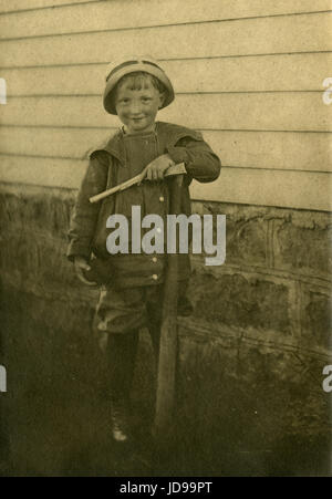 Antique c1905 la fotografia del bambino con pistola giocattolo, bat e la sfera. La posizione è probabilmente Mankato, Minnesota. Fonte: fotografia originale. Foto Stock