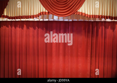 Rosso tendina chiusa con macchie di luce in un teatro. Foto Stock