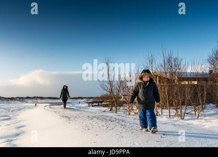 Madre e figlio passeggiate in paesaggi innevati, Islanda, l'Europa. Natura Islanda 2017 freddo inverno Foto Stock