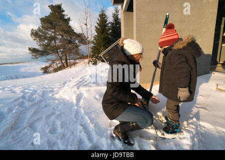 Madre e Figlio nella neve madre accovacciato accanto al figlio figlio tenendo la pala ontario canada freddo inverno 2017 snow Foto Stock