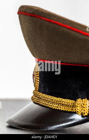 Visiera cappello militare, giacente sul tavolo, close-up Foto Stock