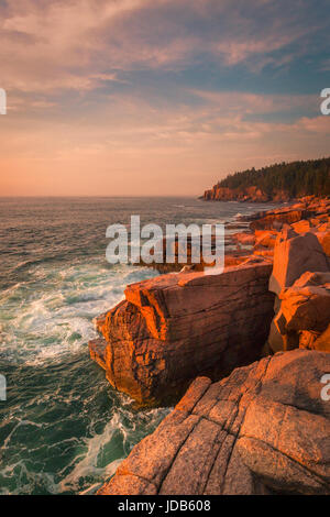 I fotografi sono disegnati per il colore rosso del granito disseminato di massi lungo il bordo orientale del Parco Nazionale di Acadia nel Maine. Foto Stock