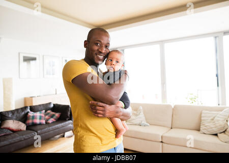 Giovani afro-padre americano tenendo il suo Figlio bambino nelle braccia Foto Stock