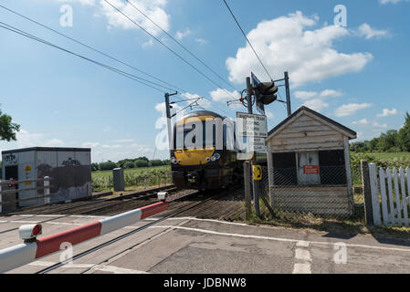 Treno in avvicinamento passaggio a livello Foto Stock