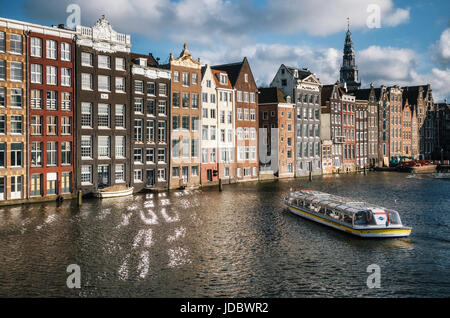 Amsterdam, Paesi Bassi - 25 April, 2017: Crociera imbarcazione turistica in Damrak canal ad Amsterdam al tramonto. Foto Stock