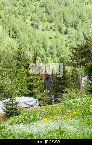 Il rumeno donna adulta di indossare un abbigliamento informale su Zip-Line, la Tettoia Esperienza in Montagna Retezat, Romania Foto Stock