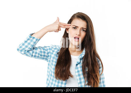 Bruna giovane ragazza in camicia a scacchi che mostra la pistola del dito gesto isolato su bianco Foto Stock