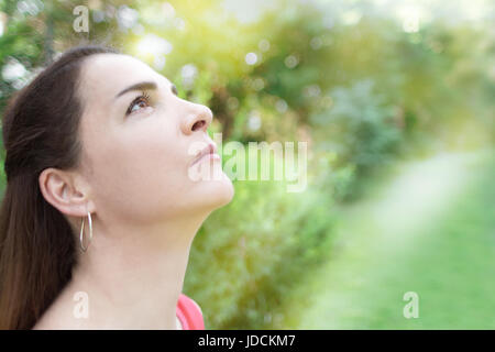 Ritratto di una donna che guarda il cielo, volendo, pregando. Foto Stock