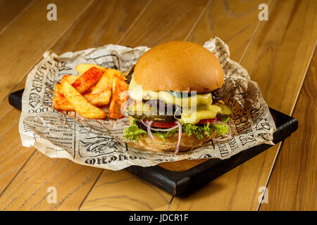 Carni bovine Craft hamburger e patatine fritte sul tavolo di legno Foto Stock