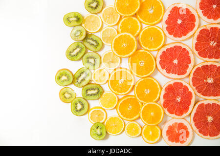Gradiente fette di agrumi - pompelmo, arancio, limone e kiwi a fette, posto su sfondo bianco da sinistra a destra, da grande di dimensioni più piccole Foto Stock