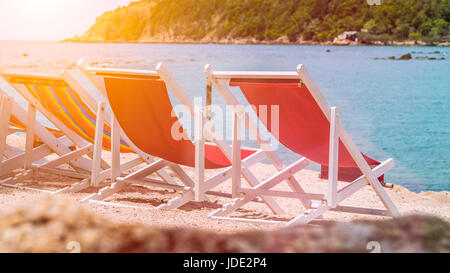 Accattivante sedie da spiaggia in sabbia. Palme e oceano in background. Haad Salat. Ko Phangan, Thailandia. Foto Stock