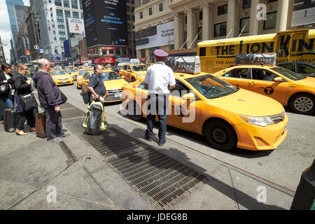 Persone in attesa alla yellow cabs fermata taxi sulla settima avenue al di fuori della stazione Penn di New York City STATI UNITI D'AMERICA Foto Stock