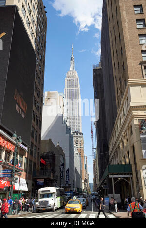 Vista lungo la West xxxiii street incluse le viste dell'Empire State Building di New York City STATI UNITI D'AMERICA Foto Stock