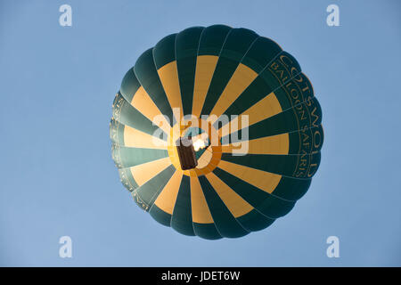 Una mongolfiera visto dal di sotto, di proprietà di cotswold balloon safaris, svasatura è il bruciatore a gas per mantenere la quota a fronte di un blu limpido cielo di sera. Foto Stock