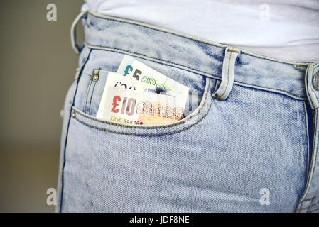 Incollaggio di denaro al di fuori di un blu jean pocket. Foto Stock