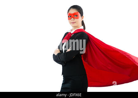 Ritratto di gentile imprenditrice vestito da supereroe in piedi con le braccia incrociate in ufficio stile isolato su copyspace di Pentecoste lo sfondo e indossa red andare Foto Stock