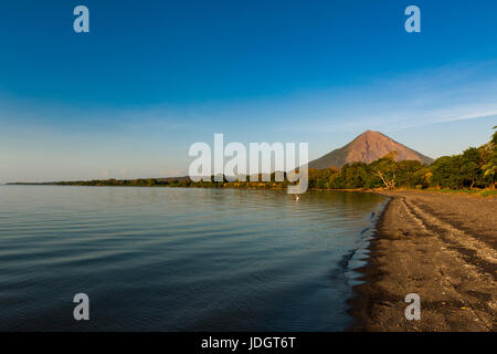 Vista di una spiaggia al tramonto nell'isola di Ometepe, con il vulcano Concepcion sullo sfondo in Nicaragua, Sud America Foto Stock