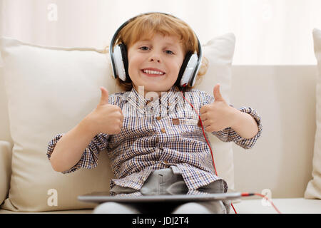 Rilassata smart kid a giocare con i suoi gadget Foto Stock