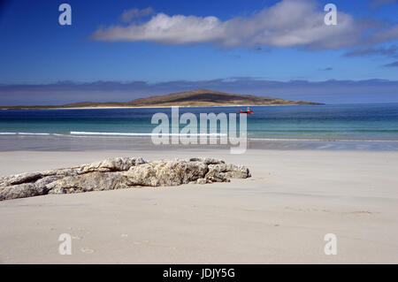 Un piccolo rosso barca da pesca passando West Beach sull'Isola di Berneray su North Uist con l'isola di Pabbay in background, Ebridi Esterne, Foto Stock