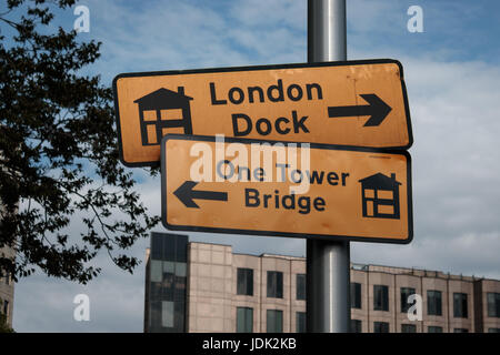 Un cartello stradale direzioni di puntamento per il Tower Bridge di Londra e il Dock Foto Stock