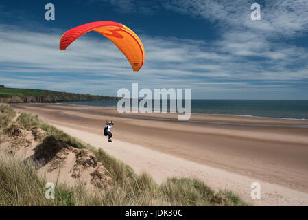 Un parapendio assume per l'aria a Lunan Bay, Angus, Scozia. Foto Stock