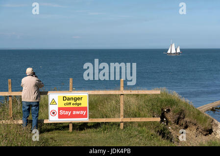 Cartelli di pericolo sul ciglio della scogliera a: Peveril Point in Swanage Bay Dorest England Regno Unito. Holidamaker prendendo foto. Giugno 2017 Foto Stock
