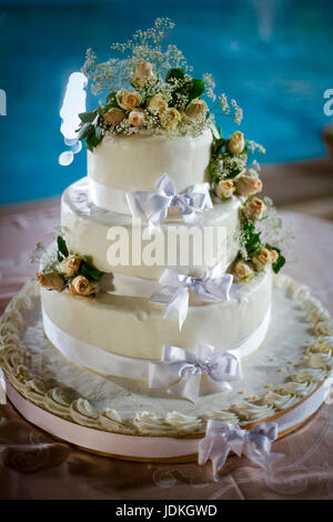 Tre-tiered withe torta di nozze con rose giallo Foto Stock