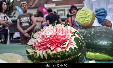 Zemun, Serbia - Uomo carving melone sul mercato verde stand Foto Stock