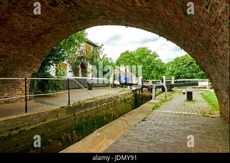 Serratura inferiore sul volo Foxton e bloccare i detentori cottage vista attraverso il passaggio a volta del ponte sul canale Foto Stock