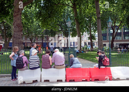 I turisti seduti, Charterhouse Square, boarder del London borough di Islington & City di Londra Inghilterra Gran Bretagna REGNO UNITO Foto Stock