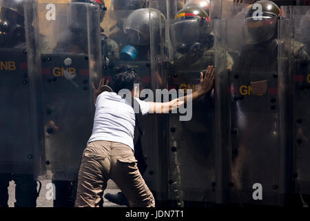 Una donna cerca di fermare un gruppo di membri della nazionale bolivariano le guardie da disperdere manifestanti su una autostrada a Caracas. Foto Stock